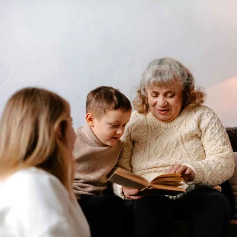 Une grand-mère lit un livre à son petit-fils sur le canapé