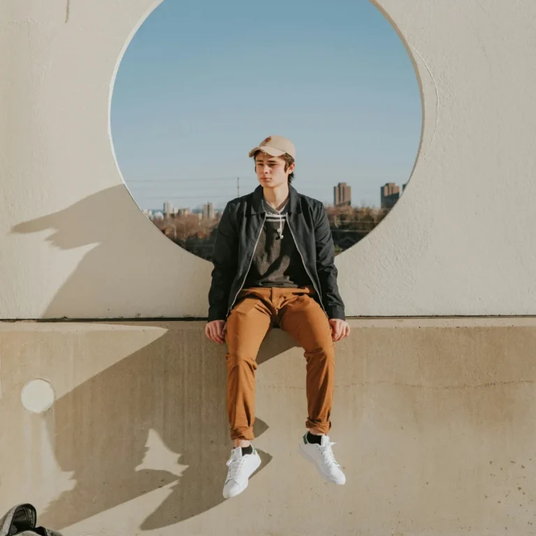 un jeune garçon assis sur un muret