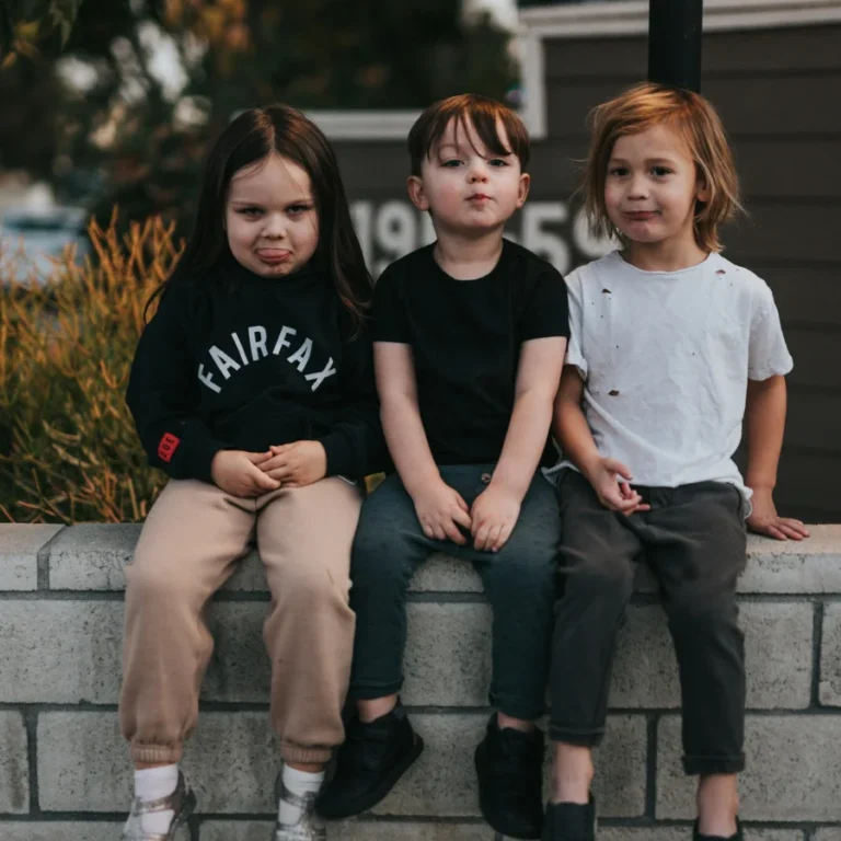 trois enfant assis sur un muret