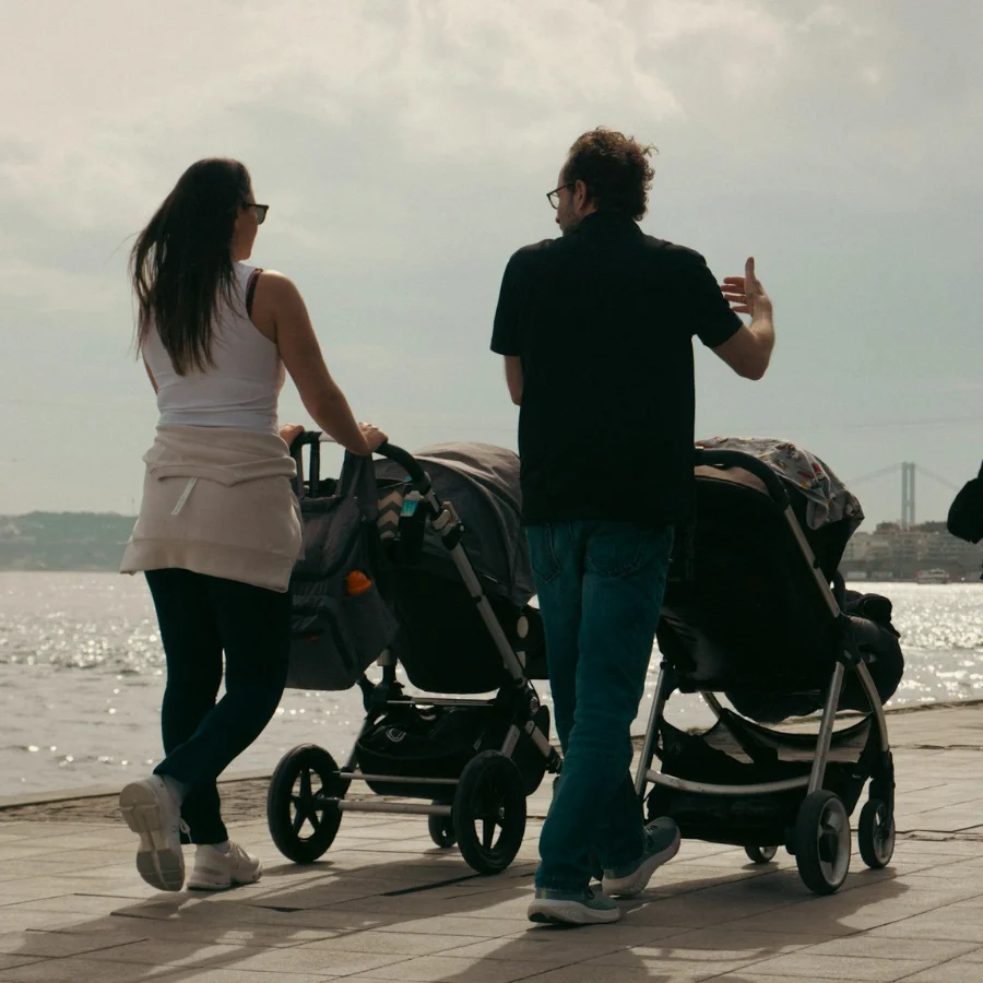 Deux parents avec une poussette en train de discuter ensemble