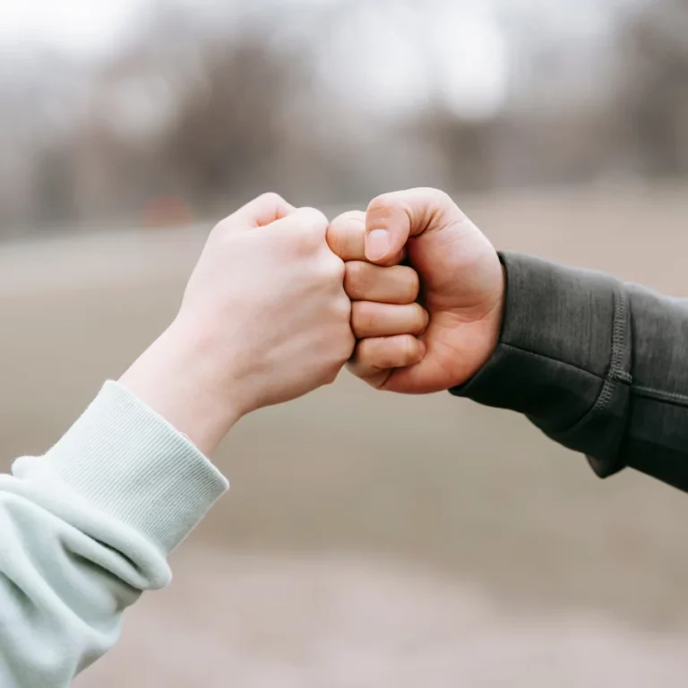 deux personnes se faisant un "check" pour signifier leur complicité