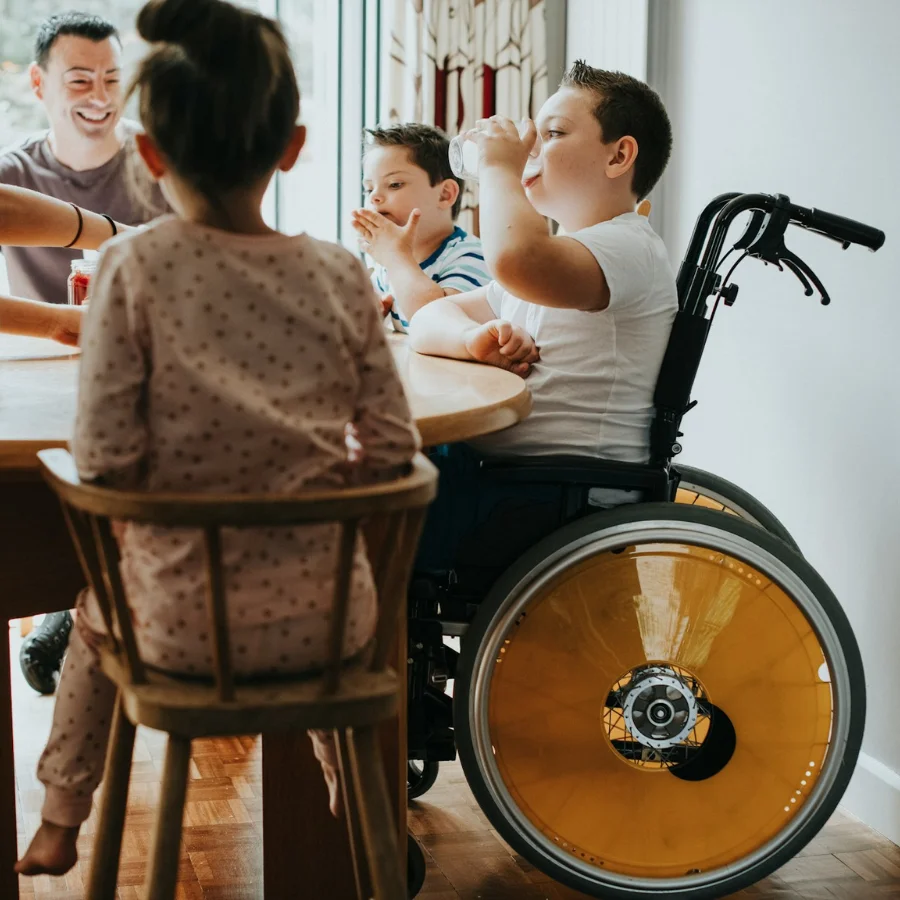 famille avec un enfant handicapé en train de déjeuner ensemble