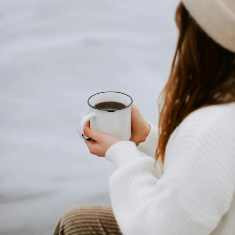 une femme tenant une tasse de café