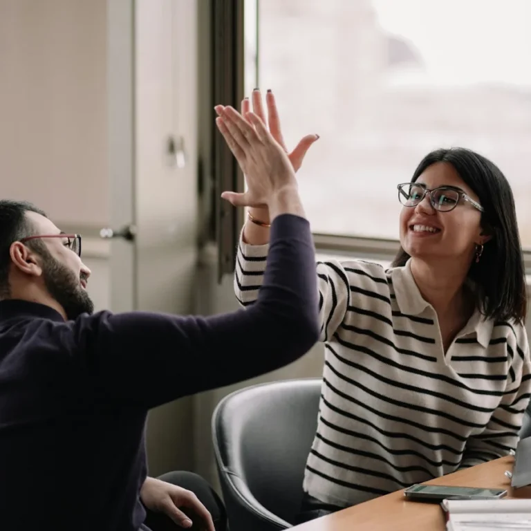 deux personnes se tapent la main car elles arrivent à mieux communiquer ensemble