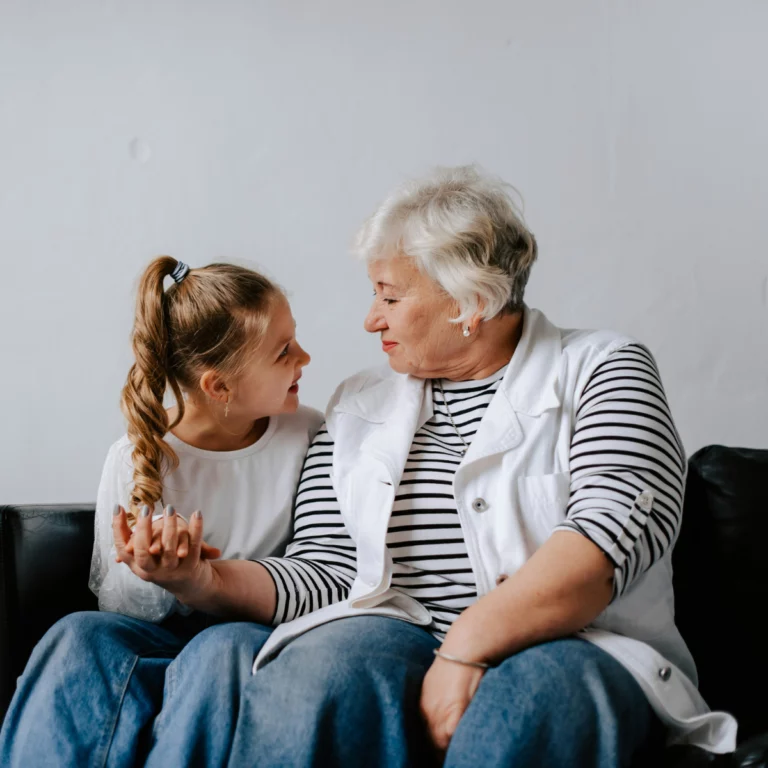 une grand-mère discute avec sa petite fille sur un canapé