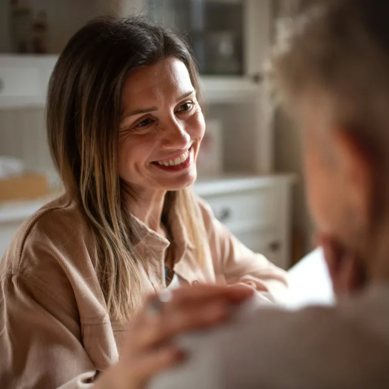 une femme posant sa main sur l'épaule de quelqu'un en signe de réconfort