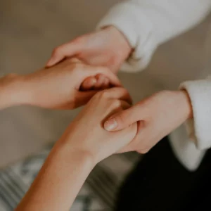 image représentant une personne soutenant une autre personne en lui tenant les mains