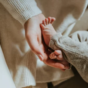 Une mère tient le pied de son bébé dans le cadre de consultations autour du post-partum