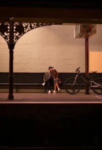 un couple assis sur un banc d'un quai de gare